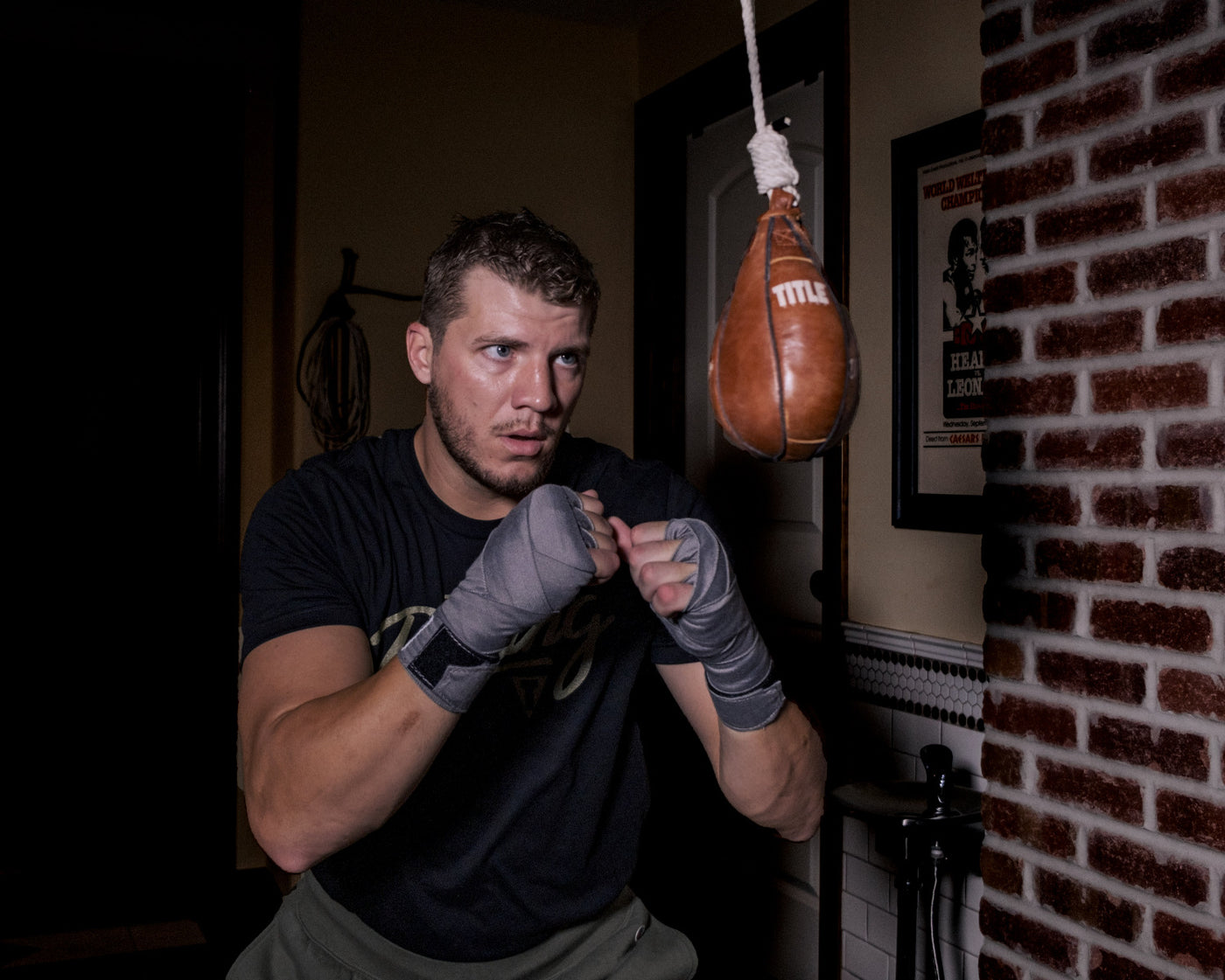 lifestyle:variant::TITLE Boxing Cus D’Amato Genuine Leather Slipping Bag man looking at slipping bag