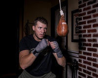 lifestyle:variant::TITLE Boxing Cus D’Amato Genuine Leather Slipping Bag man looking at slipping bag