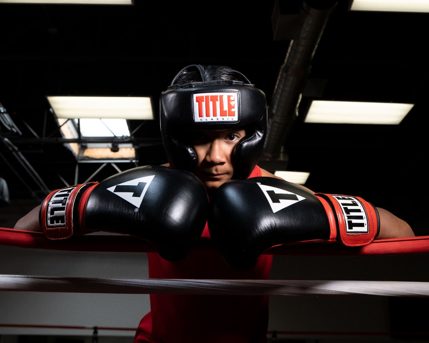 variant:black::TITLE Classic Full Coverage Training Headgear 2.0 kid in ring on ropes