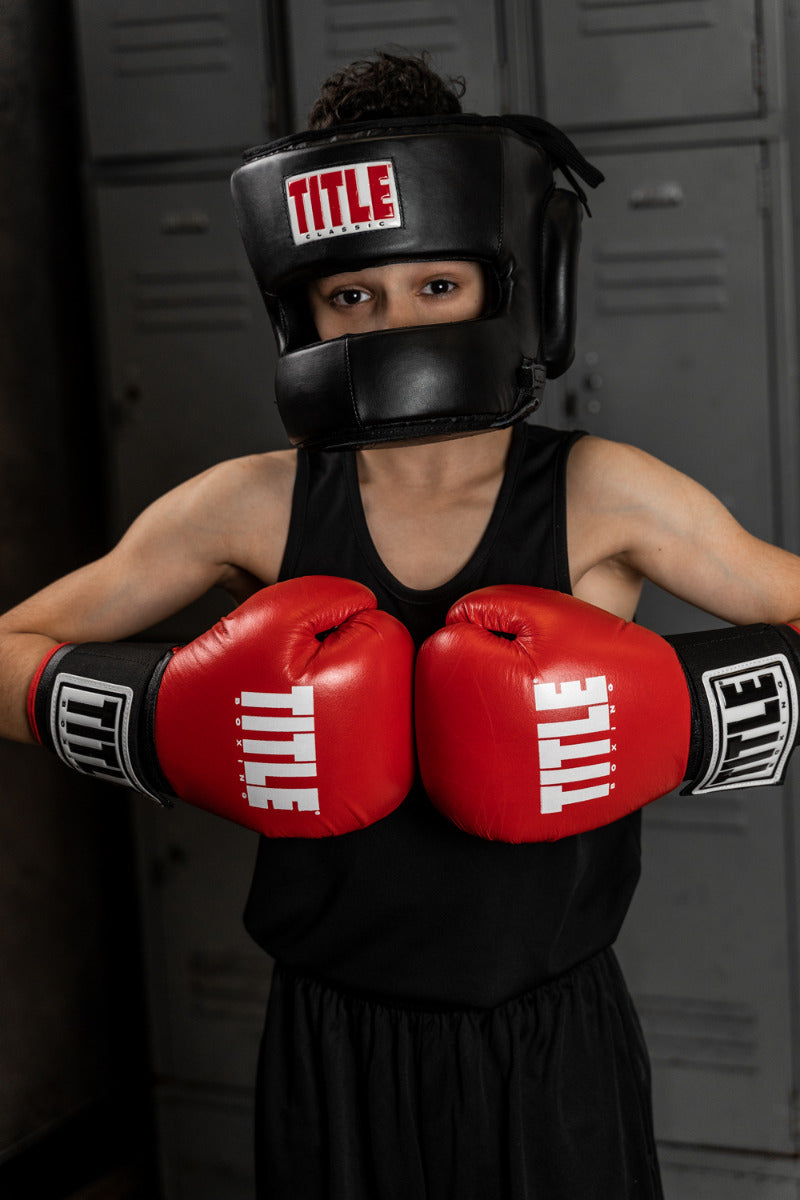 variant:lifestyle::TITLE Classic Face Protector Headgear 2.0 kid punching red gloves together 
