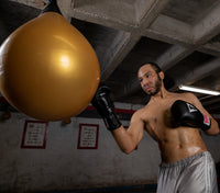 variant:black::TITLE Classic Leather Elastic Training Gloves 2.0 Media 1 of 21 guy hitting water bag