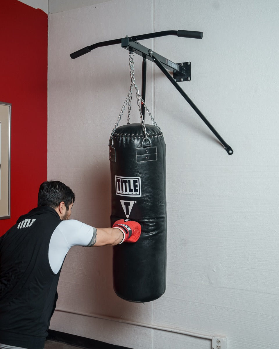 variant:lifestyle::
TITLE Boxing Deluxe Wall Mount Pull-Up Bar & Bag Hanger on a boxing gym wall with a heavy bag