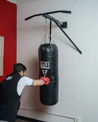 variant:lifestyle::
TITLE Boxing Deluxe Wall Mount Pull-Up Bar & Bag Hanger on a boxing gym wall with a heavy bag