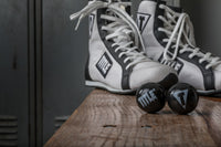 variant:lifestyle::TITLE Boxing Equipment Deodorizer Balls in front of a pair of boxing shoes