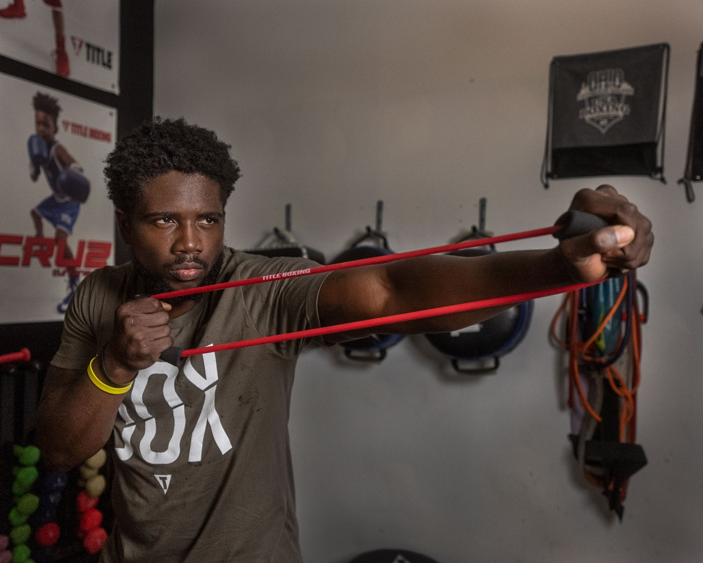 variant:lifestyle::TITLE Boxing Elliptical Resistance Bands Set with a boxer using the red band