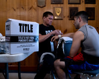 variant:lifestyle::TITLE Boxing Fist-Form Puncher’s Gauze in a boxing gym with a trainer and a fighter
