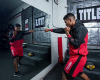 variant:lifestyle::TITLE Boxing Big Logo Banner behind a boxer training