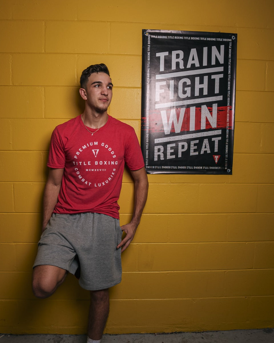 variant:lifestyle::TITLE Boxing Train Fight Win Repeat Banner hanging in a boxing gym
