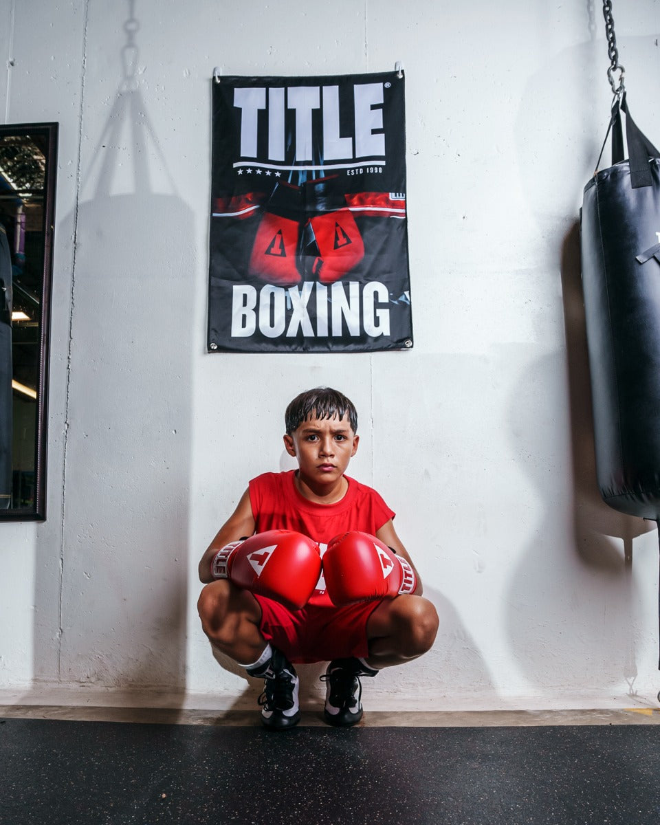 variant:lifestyle::TITLE Boxing Pro Fight Banner behind youth boxer
