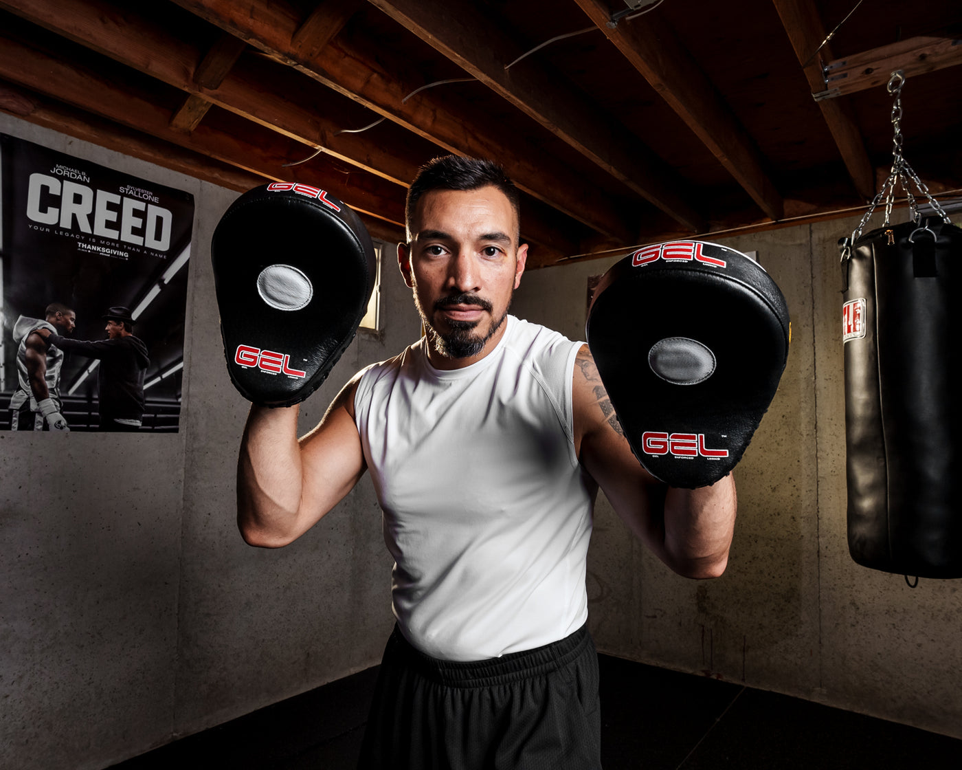 variant:lifestyle::TITLE Boxing Gel World Contoured Punch Mitts coach holding up mitts