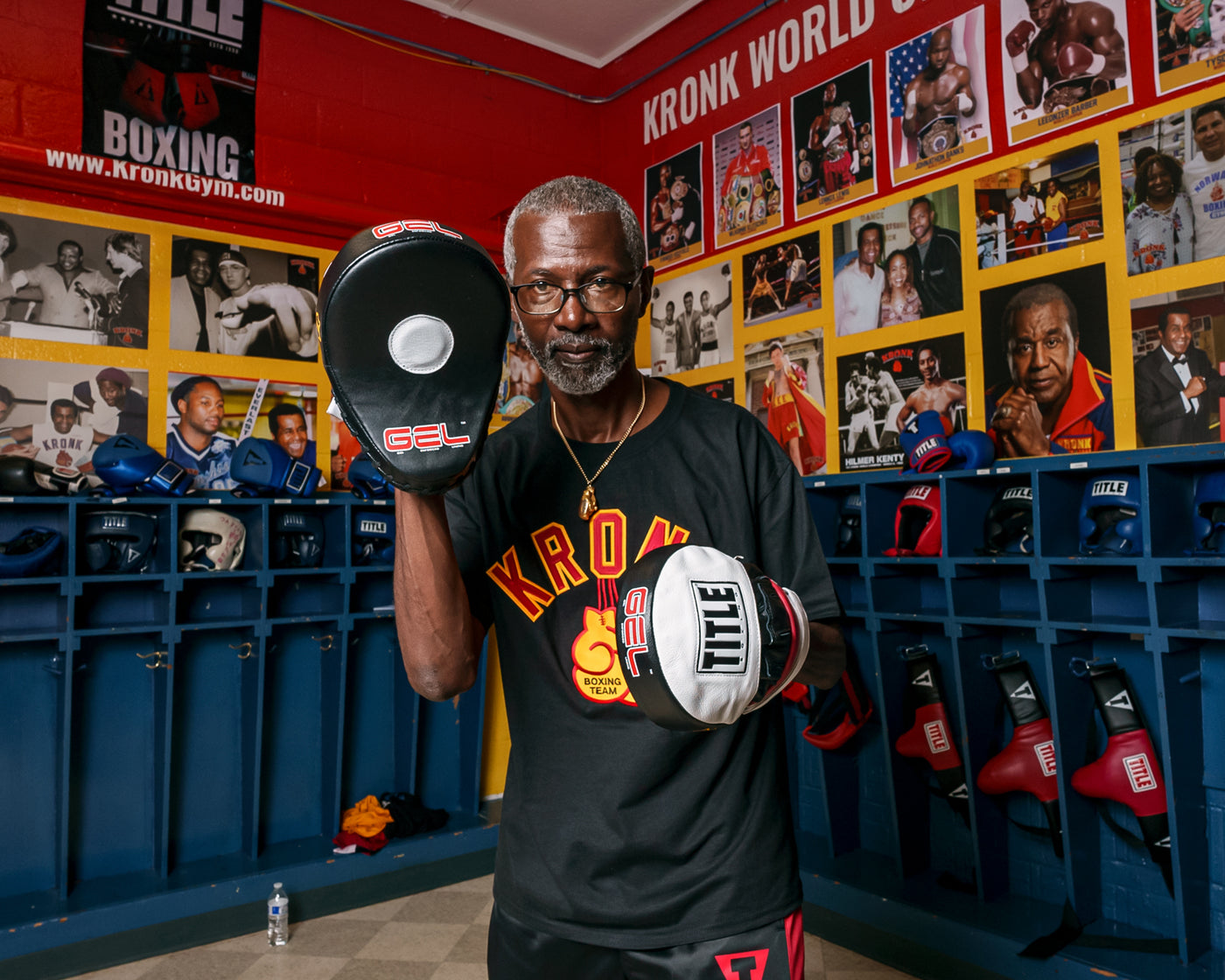 variant:lifestyle::TITLE Boxing Gel World Contoured Punch Mitts coach with kronk tee on