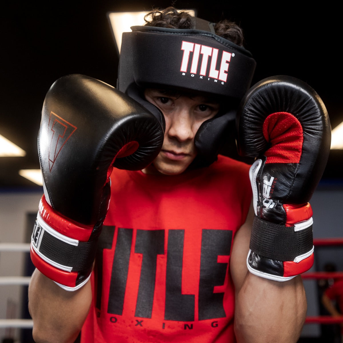 variant:lifestyle::TITLE Boxing Gel Washable Training Headgear man posing with headgear and gloves