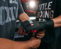 variant:lifestyle::TITLE Boxing Gel Iron Fist Slip-On Knuckle Shields 2.0 man getting hands wrapped