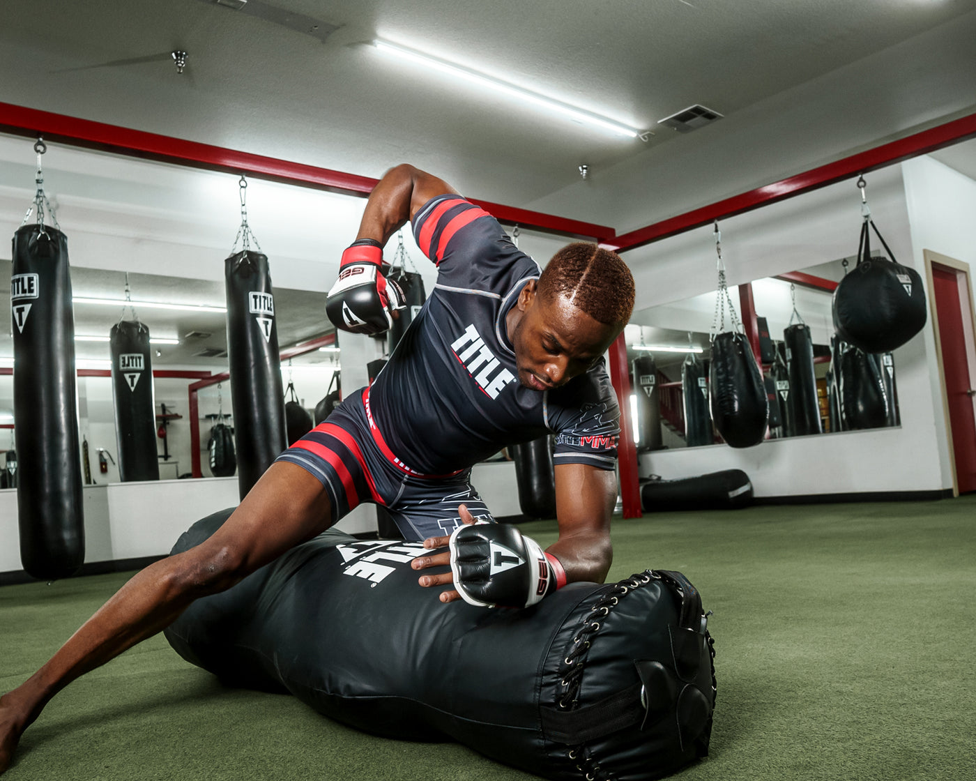 variant:Black/White/Red::TITLE Boxing Gel Incensed Wristband Heavy Bag Gloves guy in boxing gym wearing gloves boxing with heavy bag