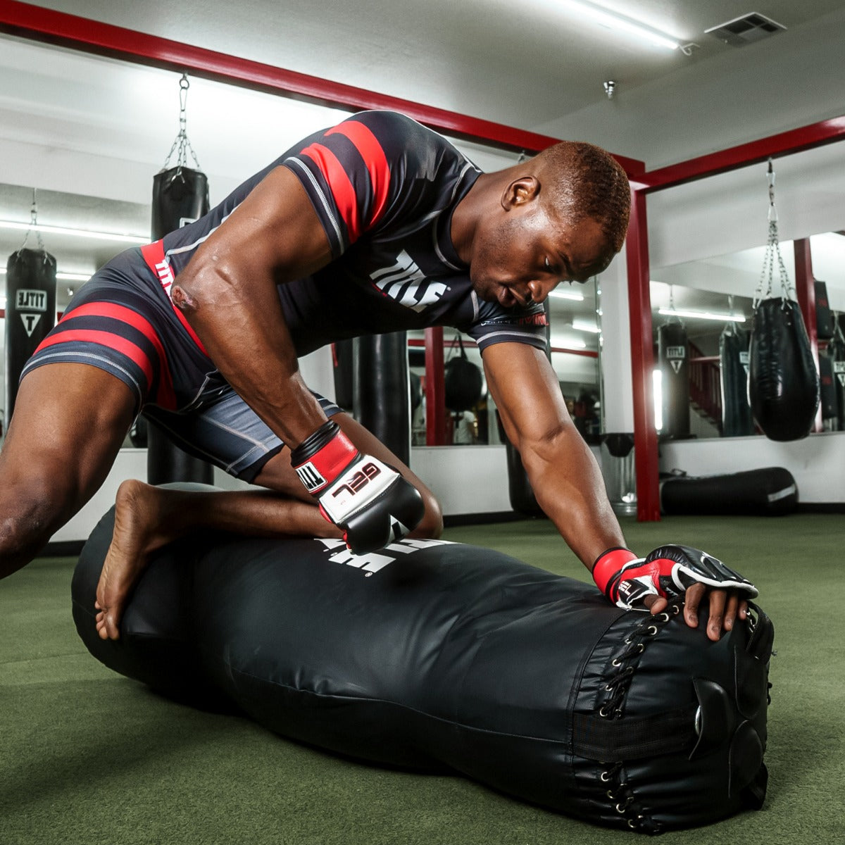 variant:Black/White/Red::TITLE Boxing Gel Incensed Wristband Heavy Bag Gloves guy wearing gloves boxing with heavy bag