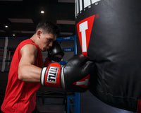 variant:Black/White/Red::TITLE Boxing Gel Weighted Boxing Gloves person wearing boxing gloves punching heavy bag