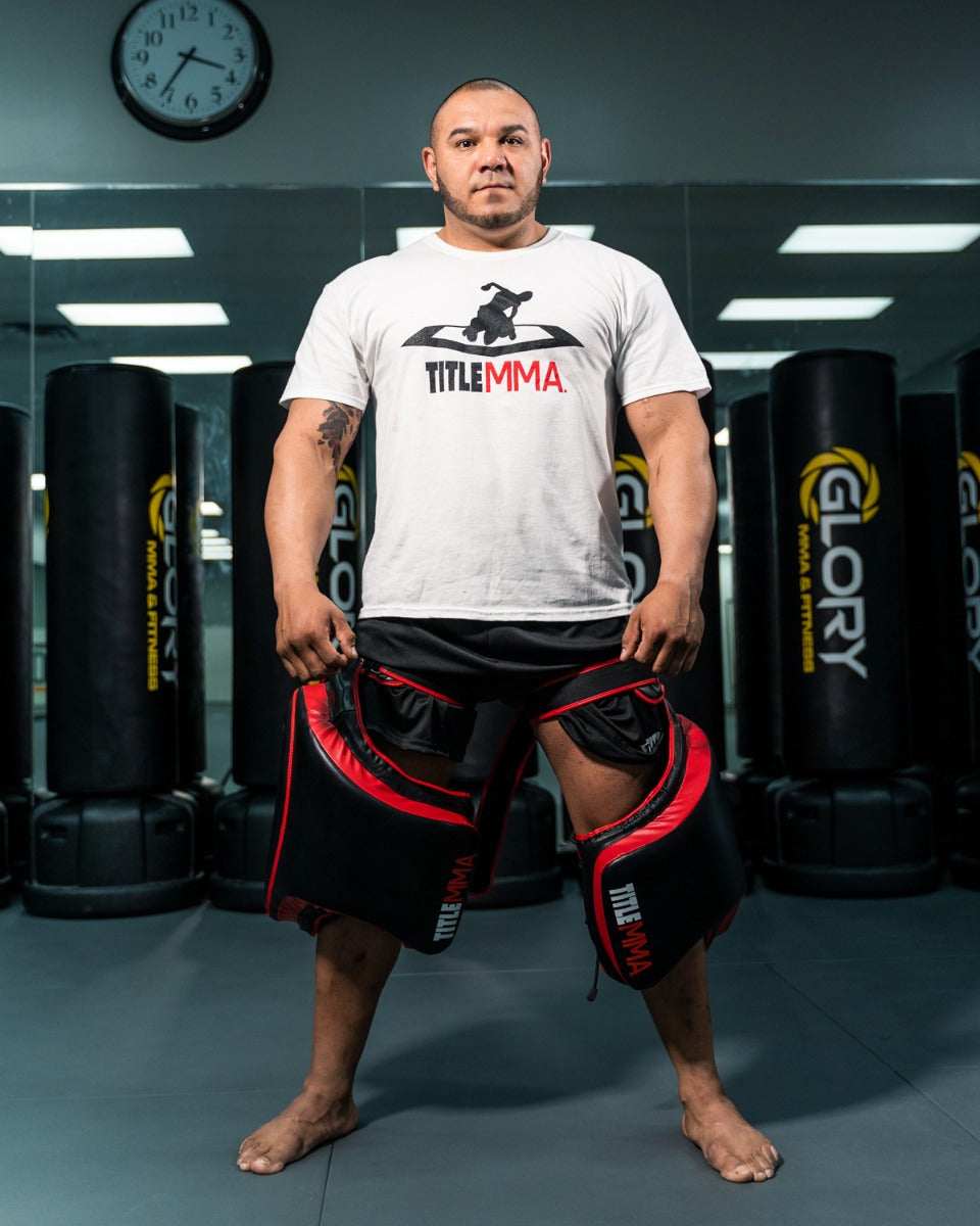 variant:lifestyle::TITLE MMA Gel Thai Style Thigh Pads 2.0 man posing with pads