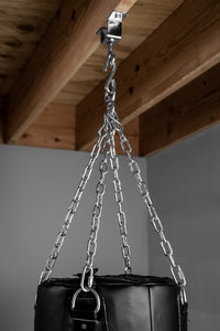 variant:lifestyle::TITLE Boxing Heavy-Duty Heavy Bag Chain & Swivel - Up To 150 lbs in use on a wood beam with a heavy bag