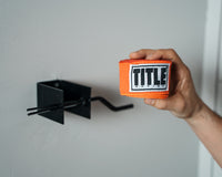 variant:lifestyle::TITLE Boxing Metal Hand Wrap Roller with a pair of rolled hand wraps
