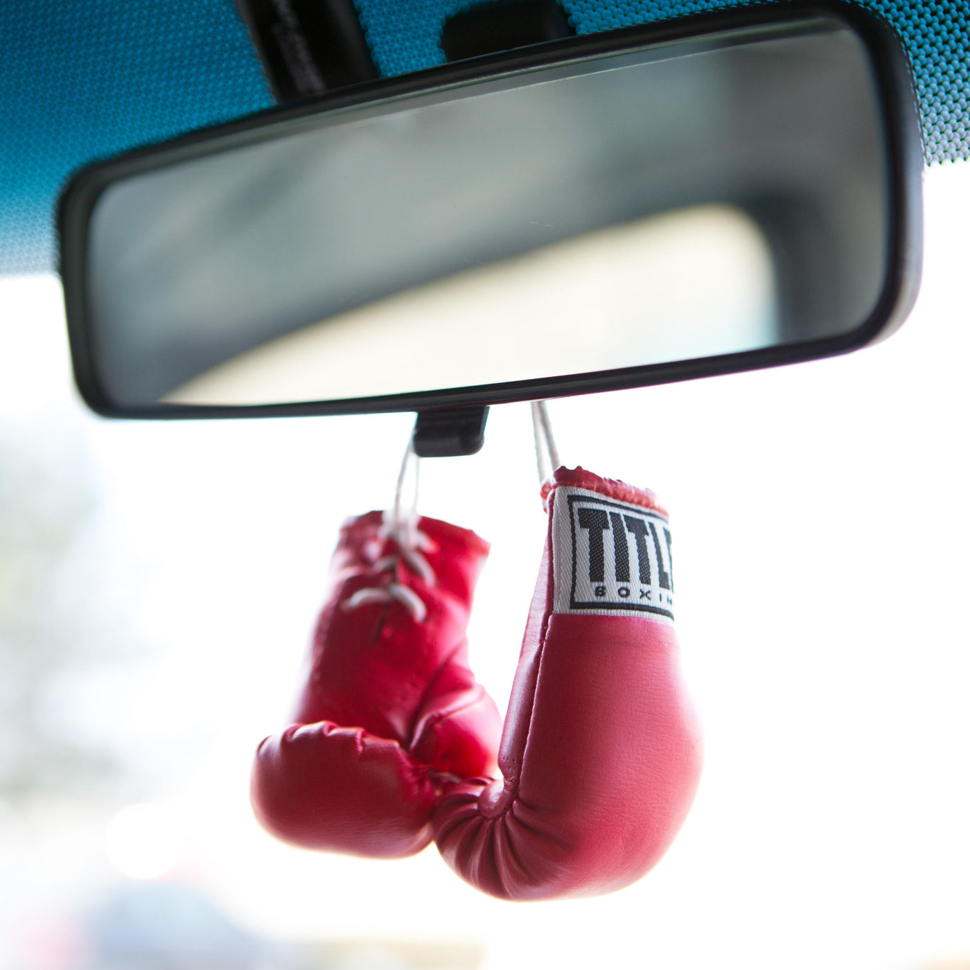variant:pink::TITLE Boxing 3.5” Mini Boxing Gloves hanging off mirror in car