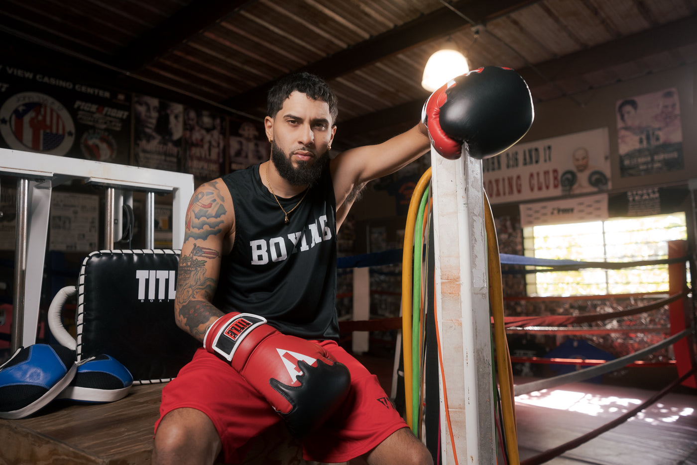 variant:Red/Black/White::TITLE Boxing Gel Lava Leather Series Training Gloves guy sitting by ring
