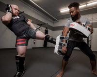  variant:black/white/grey::TITLE MMA Air Raid Thai Pads (Pair) guy kicking