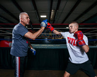 variant:lifestyle::TITLE Platinum Perilous Micro Palm Mitts kid and coach training in boxing gym
