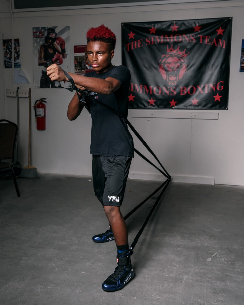 variant:lifestyle::TITLE Boxing Powerquad Resistance System being used by a boxer in a boxing gym