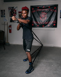 variant:lifestyle::TITLE Boxing Powerquad Resistance System being used by a boxer in a boxing gym