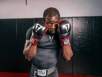 variant:lifestyle::TITLE MMA Perform Safe Spar Glove 2.0 guy posing wearing gloves