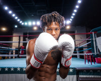 variant:lifestyle::TITLE Boxing Gel Special Edition Bag Gloves guy posing in gloves next to boxing ring