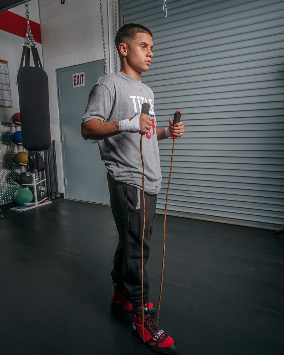 variant:lifestyle::TITLE Classic Leather Speed Rope 2.0 guy holding jump rope underneath foot