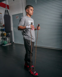 variant:lifestyle::TITLE Classic Leather Speed Rope 2.0 guy holding jump rope underneath foot