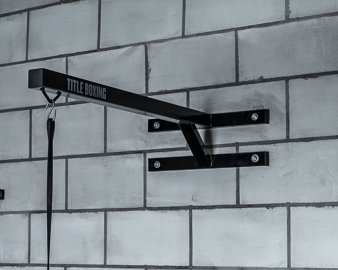 variant:lifestyle::TITLE Boxing Space Saver Wall Mount Bag Hanger 2.0 hanging on the wall of a boxing gym