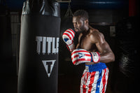 variant:lifestyle::TITLE Boxing Infused Foam Combat USA Training Gloves guy hitting bag