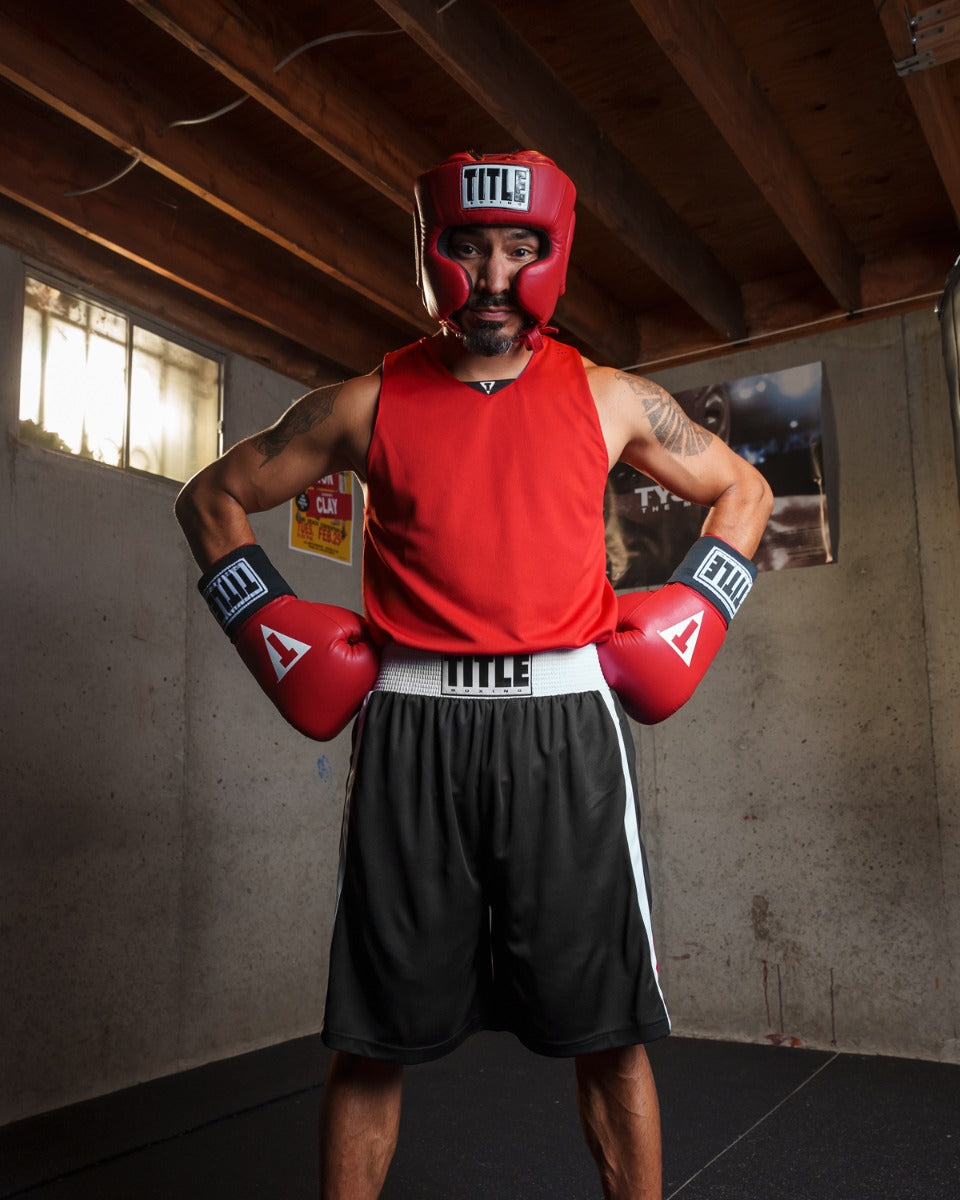 variant:lifestyle::TITLE Boxing Superior Lightweight Reversible Competition Jersey man posing with gloves