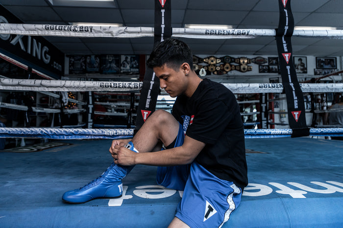 variant:Blue::TITLE Boxing Speed-Flex Encore High-Top Shoes man tying shoelaces
