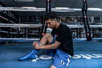 variant:Blue::TITLE Boxing Speed-Flex Encore High-Top Shoes man tying shoelaces