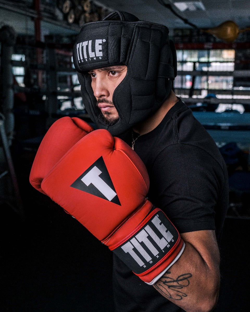 variant:lifestyle::TITLE Boxing Weighted Headgear man in headgear holding up arms