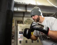 variant:lifestyle::TITLE Boxing Professional Old School Leather Bag Gloves 3.0 man about to punch a bag