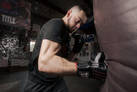variant:lifestyle::TITLE Boxing Professional Old School Leather Bag Gloves 3.0 man punching a bag