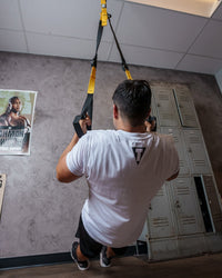 variant:lifestyle::TITLE Boxing Suspension Training System 2.0 attached to the ceiling of a boxing gym