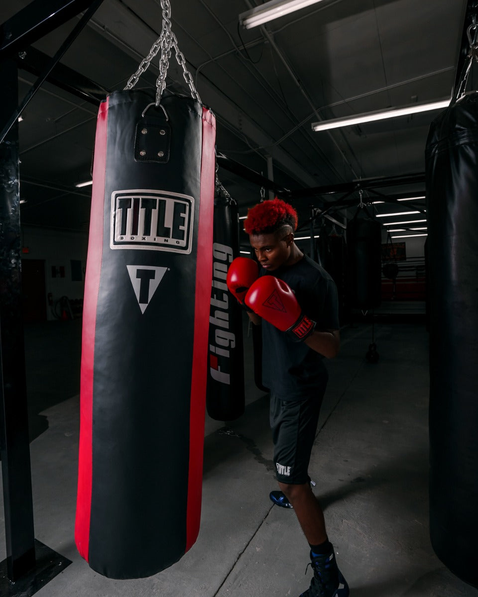 variant:lifestyle::TITLE Boxing Synthetic Leather Heavy Bag (Unfilled) Man posing with filled bag