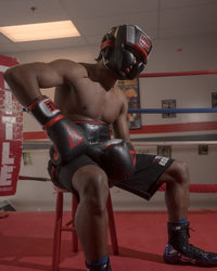 variant:lifestyle::TITLE Boxing Valiant Training Headgear man sitting in chair wearing headgear
