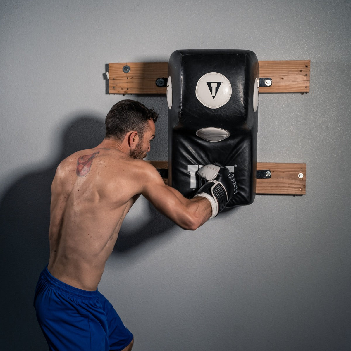 variant:lifestyle::TITLE Boxing Wall Mount Menace Training Bag front view on boxing gym wall