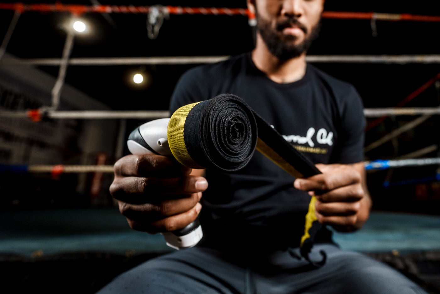 variant:lifestyle::TITLE Boxing Wrap Wrench with a boxer using it to roll a hand wrap