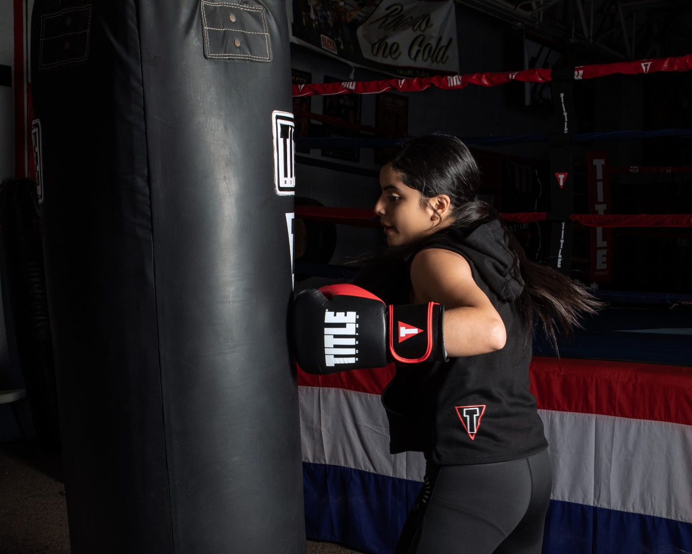 variant:Black/Red::TITLE Boxing Dynamic Strike Heavy Bag Gloves girl punching heavy bag