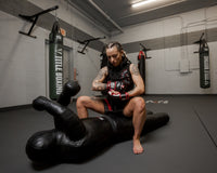 variant:Black/White/Red::TITLE MMA Conflict Pro Fight Gloves woman wearing gloves with sparring mannequin