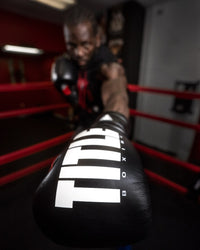 variant:Black/Silver::TITLE Boxing Leather Enforcer Pro Sparring Gloves man punching wearing sparring gloves