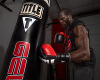 variant:Black/Silver::TITLE Boxing Leather Enforcer Pro Sparring Gloves man wearing gloves hitting bag
